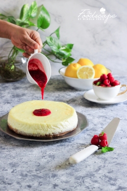 A lush, creamy Baked Lemon Cheesecake topped with a tangy and delicious Raspberry Sauce. A beautiful Spring/Summer Dessert, Lemon Dessert recipe, that is sure to be among your favourites! Cheesecake Recipe. Food Photography